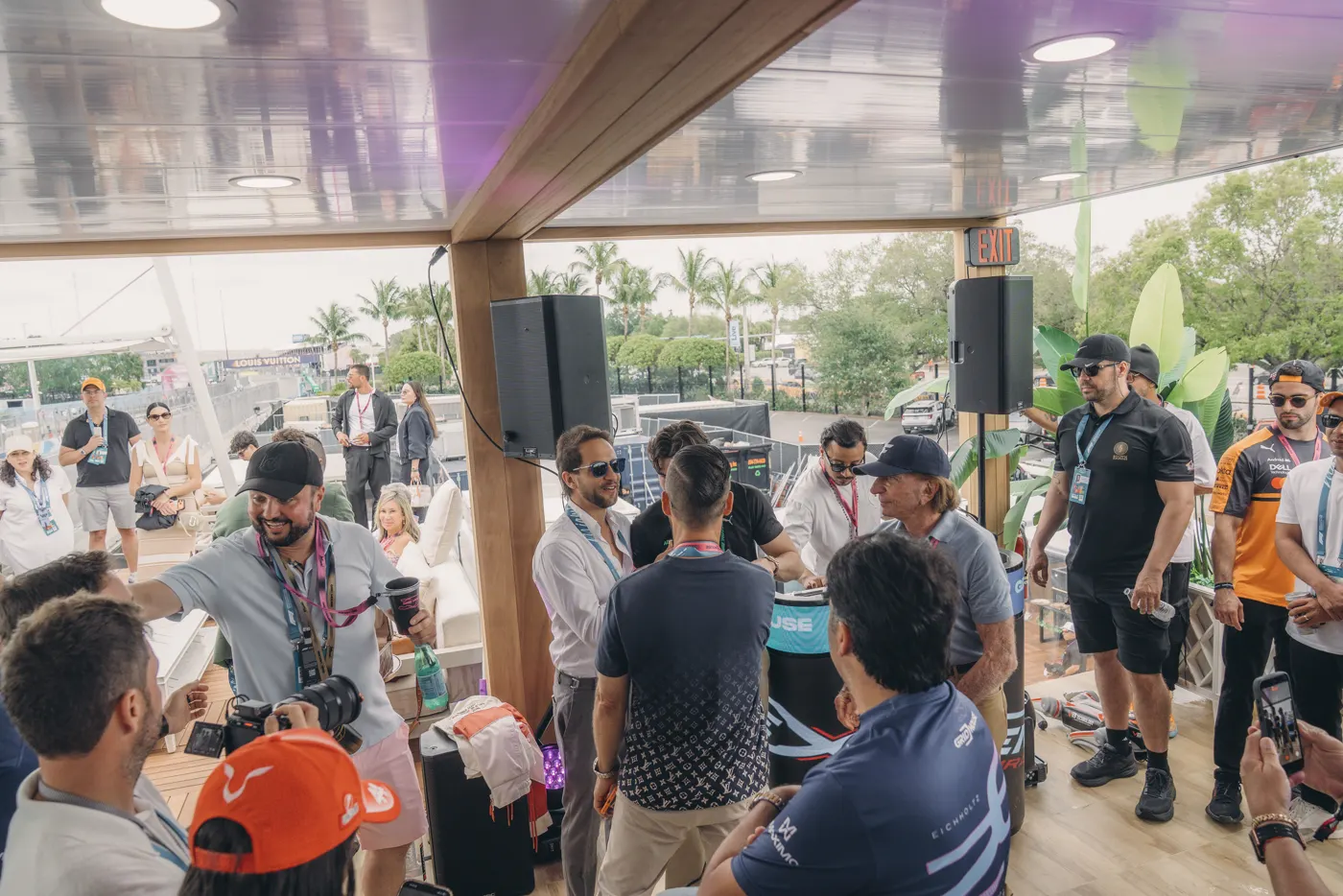 Guests at the rail as cars pass on the Miami circuit