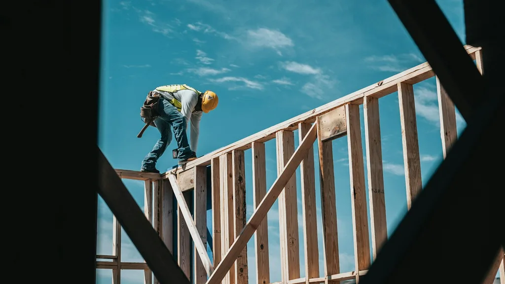 Construction worker on the wooden frame of a house under construction